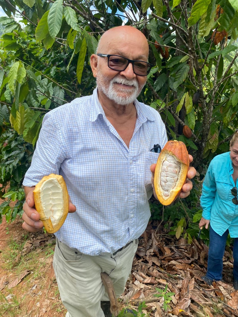 Perfecto holding two freshly opened cacao pods